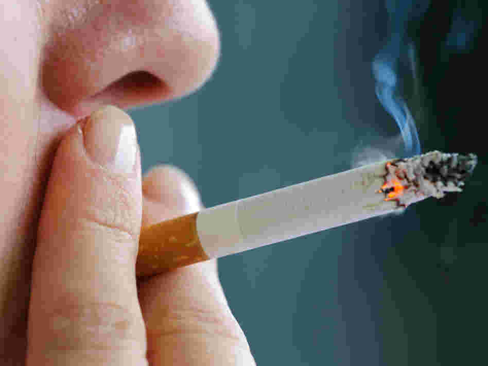 A woman puffs on a cigarette.