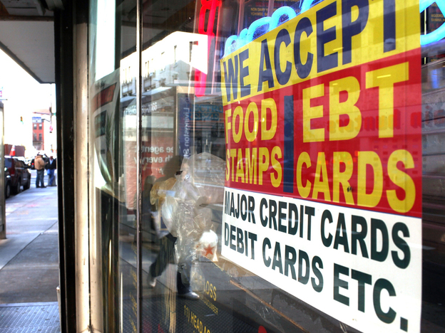 A sign in a New York City market window advertises the acceptance of food stamps.