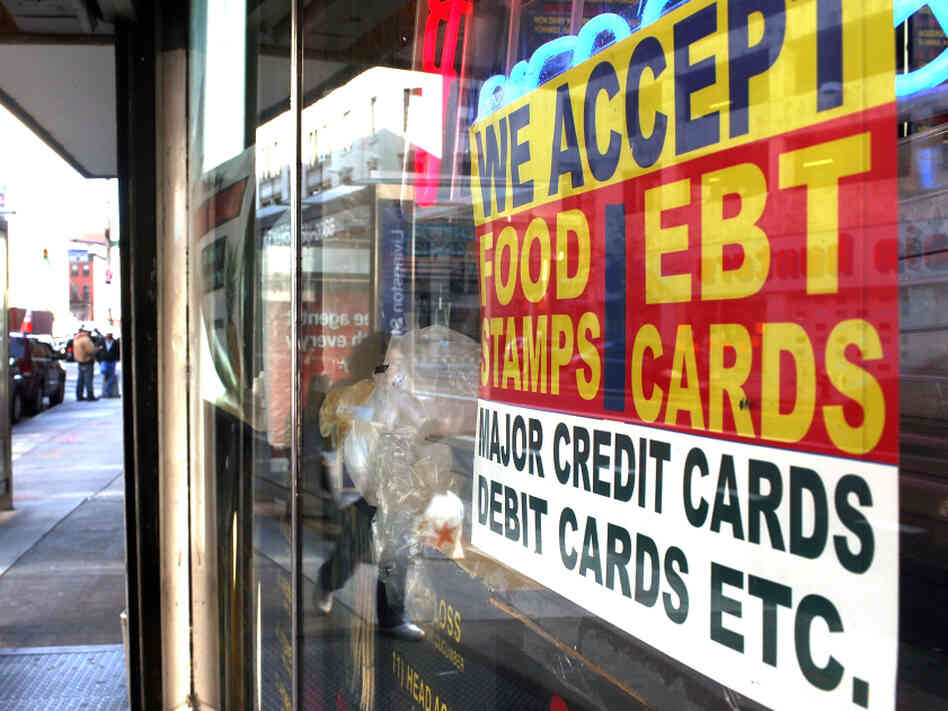 A sign in a New York City market window advertises the acceptance of food stamps.