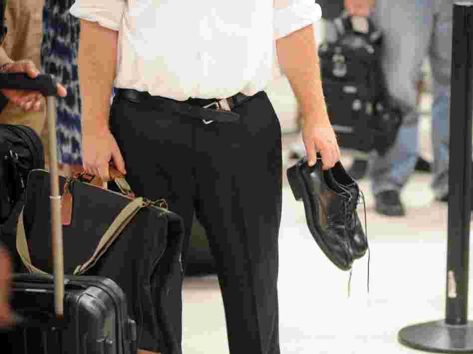 An experienced airline passenger holds his  shoes and has an unloosened belt while waiting to go through the TSA  security checkpoint at Hartsfield-Jackson Atlanta International  Airport last month.