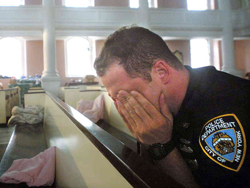 An NYPD police officer takes comfort in St. Paul's Episcopal Chapel, near the site of the World Trade Center attack, September 21, 2001. An NYPD police officer takes comfort in St. Paul's Episcopal Chapel, near the site of the World Trade Center attack, September 21, 2001.