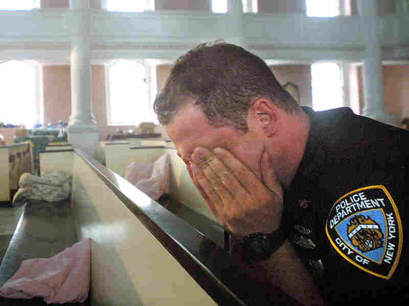 An NYPD police officer takes comfort in St. Paul's Episcopal Chapel, near the site of the World Trade Center attack, September 21, 2001. An NYPD police officer takes comfort in St. Paul's Episcopal Chapel, near the site of the World Trade Center attack, September 21, 2001.