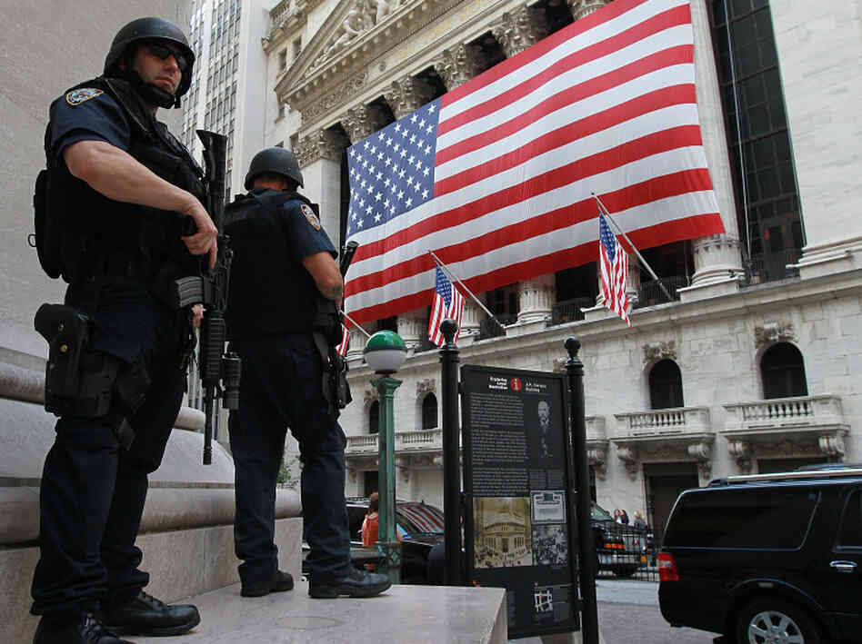 New York City policemen stand guard near the New York Stock Exchange on Friday. Security in New York and Washington has been stepped up based on what the government is calling a credible but unconfirmed threat of a possible car bomb attack.