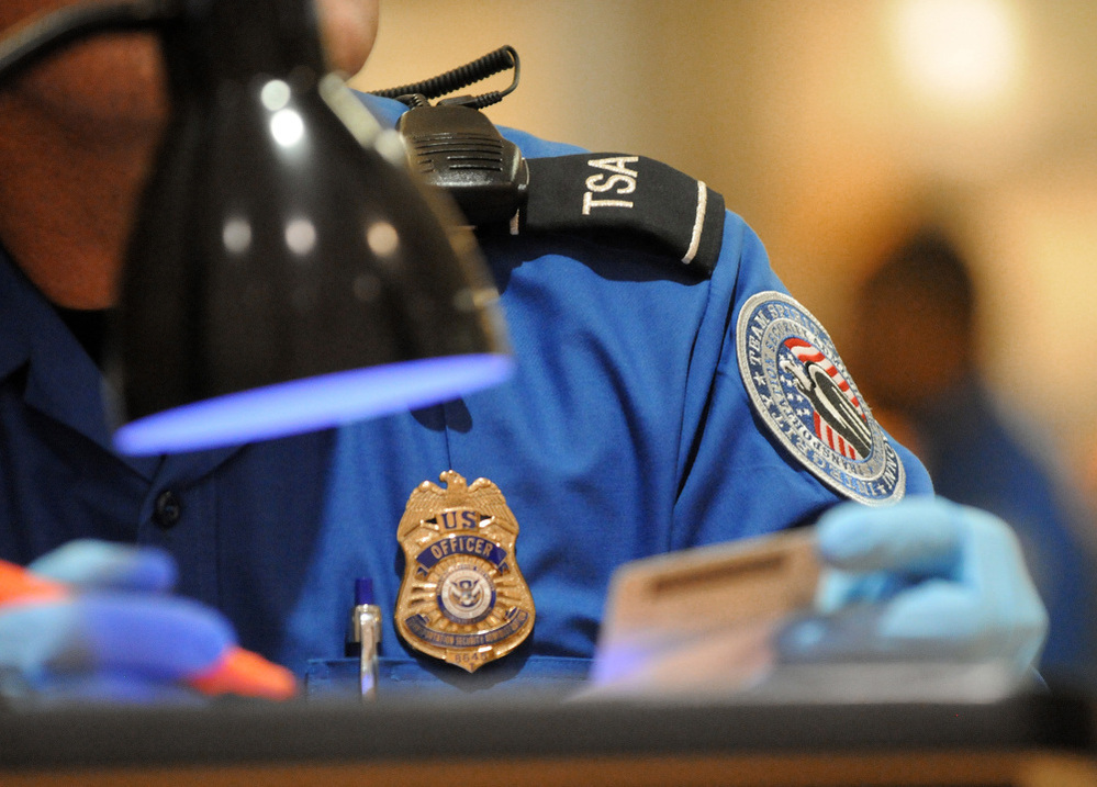 A TSA agent checks the identification of airline passengers at Hartsfield-Jackson Atlanta International Airport.