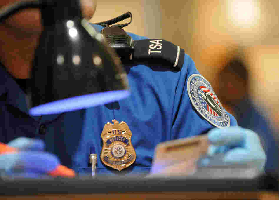 A TSA agent checks the identification of airline passengers at Hartsfield-Jackson Atlanta International Airport.