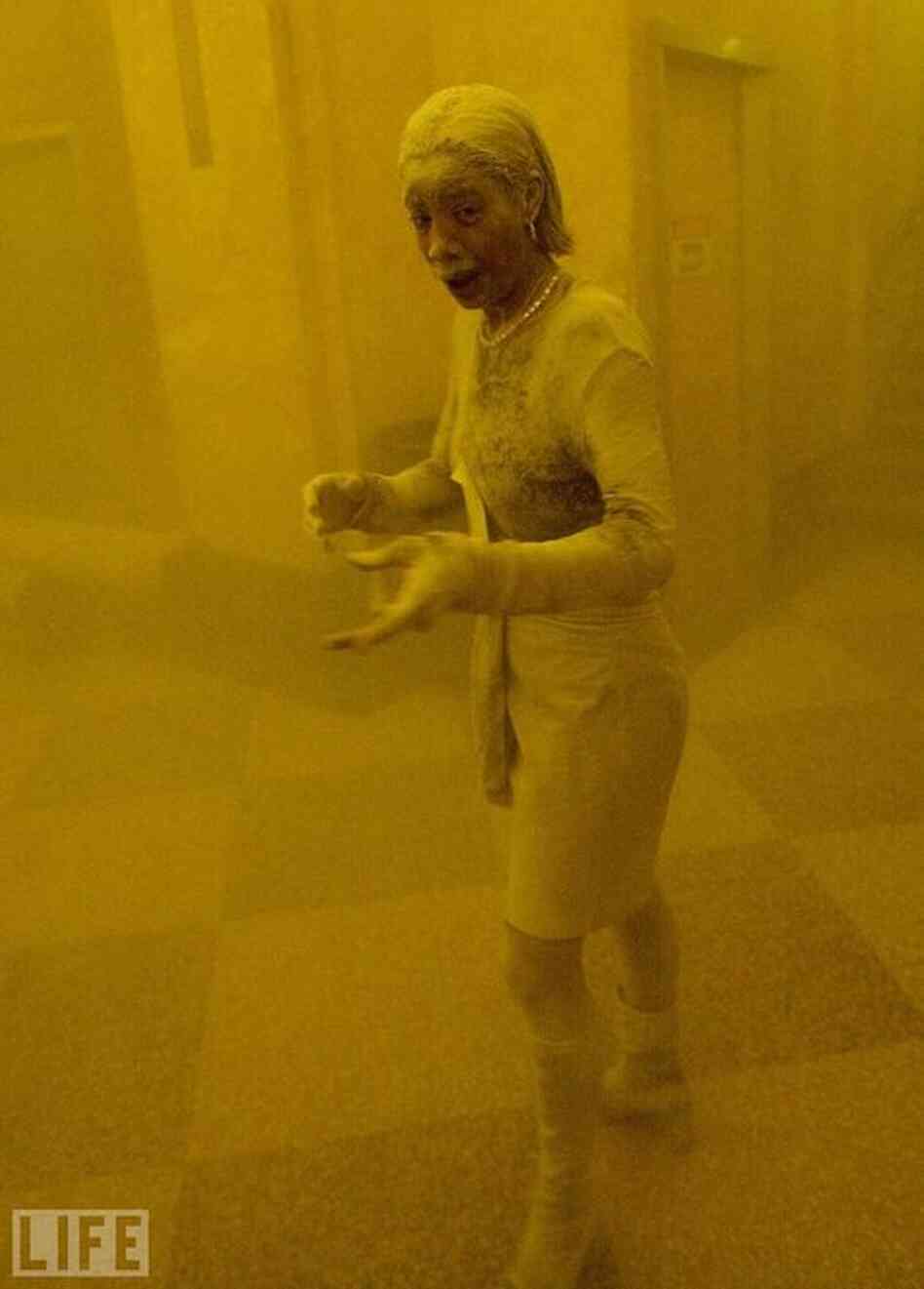Stunned, frightened, Marcy Borders, 28, is covered in dust as she takes refuge in an office building after one of the World Trade Center towers collapsed. Borders was caught outside on the street as the cloud of smoke and dust enveloped the area, and raced into the building seeking shelter. 