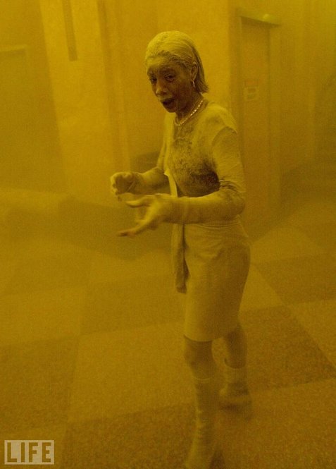 Stunned, frightened, Marcy Borders, 28, is covered in dust as she takes refuge in an office building after one of the World Trade Center towers collapsed. Borders was caught outside on the street as the cloud of smoke and dust enveloped the area, and raced into the building seeking shelter. 