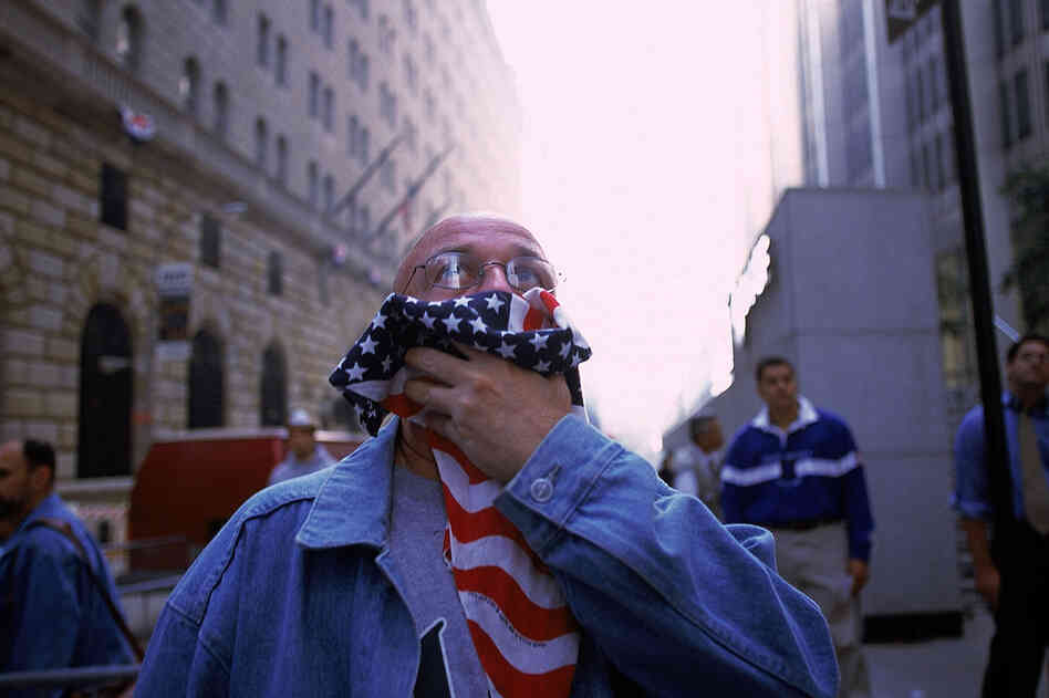 A man covers his mouth to keep out the acrid air. 