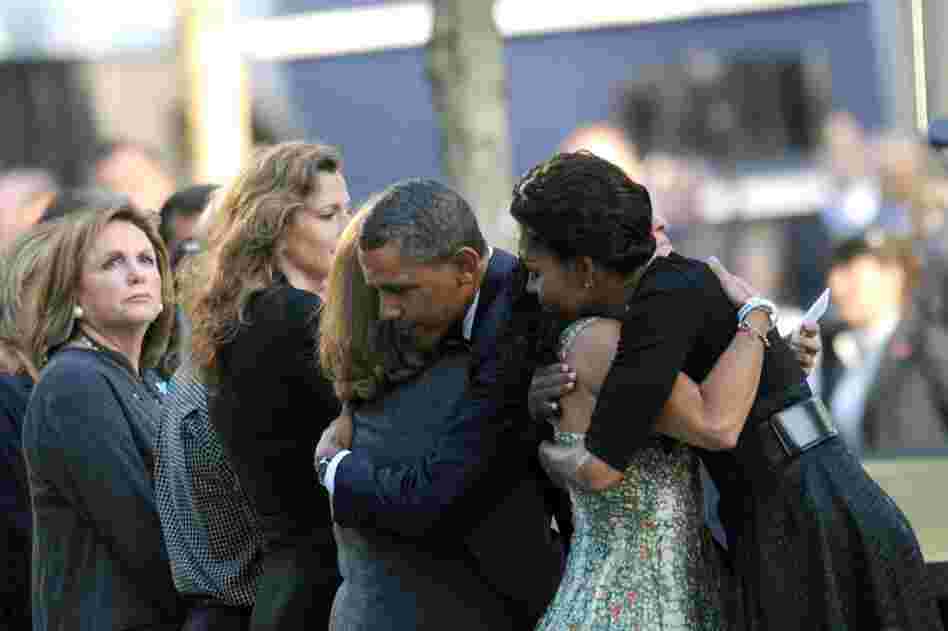 President Barack Obama and first lady Michelle Obama hug people during ceremonies at the 9/11 Memorial. 