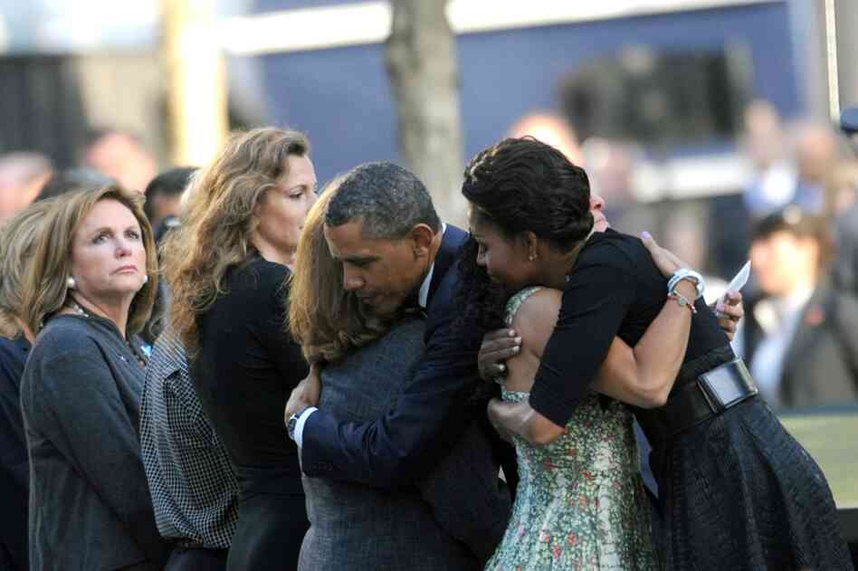 President Barack Obama and first lady Michelle Obama hug people during ceremonies at the 9/11 Memorial. 