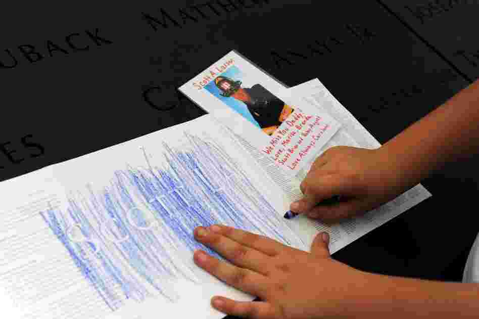 August Larsen, 9, makes a rubbing of his father's name from panels bearing the names of Sept. 11 victims at the 9/11 Memorial. 