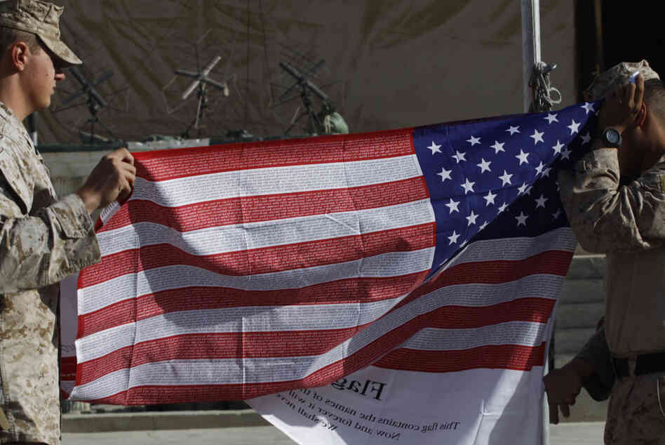 U.S. Marines fold a memorial American flag imprinted with the names of the Sept. 11, 2001 attack victims, after raising and lowering it to mark ten years since the attack, at Forward Operating Base Jackson, in Sangin, Helmand province. U.S. Marines fold a memorial American flag imprinted with the names of the Sept. 11, 2001 attack victims, after raising and lowering it to mark ten years since the attack, at Forward Operating Base Jackson, in Sangin, Helmand province.