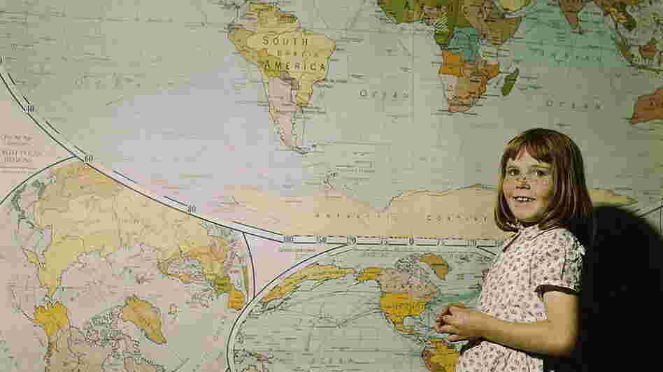 A schoolgirl in Texas stands in front of a map in 1943.