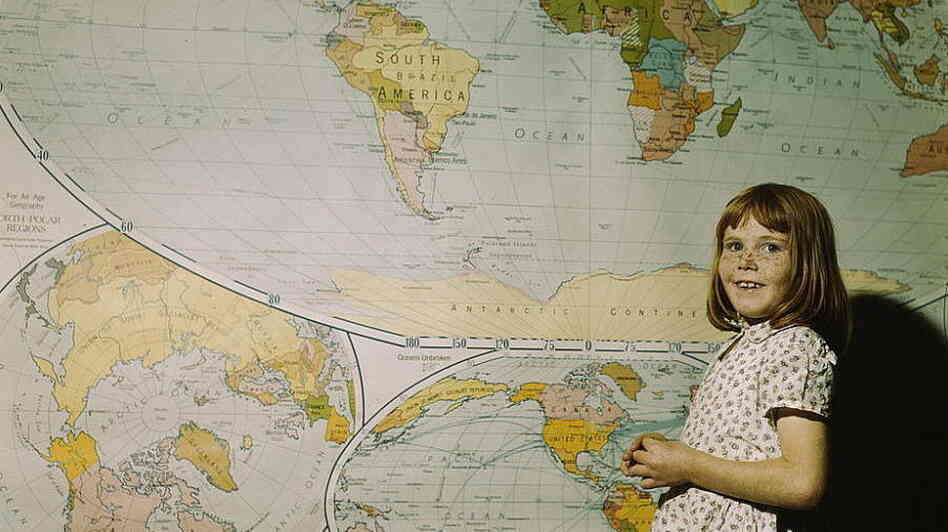 A schoolgirl in Texas stands in front of a map in 1943.