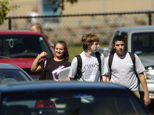 Students walk to their cars after school at Severna Park High School in Severna Park, Md. Researchers say tougher licensing laws have led to fewer fatal car crashes involving 16-year-old drivers.