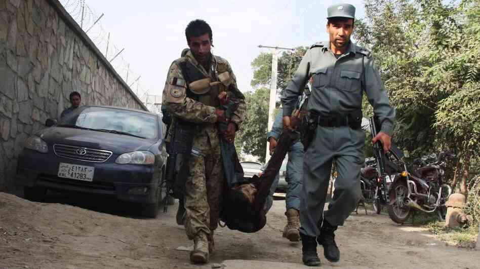 Afghan security officials carry the body of a fallen comrade after several armed Taliban militants launched attacks in Kabul, Afghanistan, on Tuesday. Afghan security officials carry the body of a fallen comrade after several armed Taliban militants launched attacks in Kabul, Afghanistan, on Tuesday.