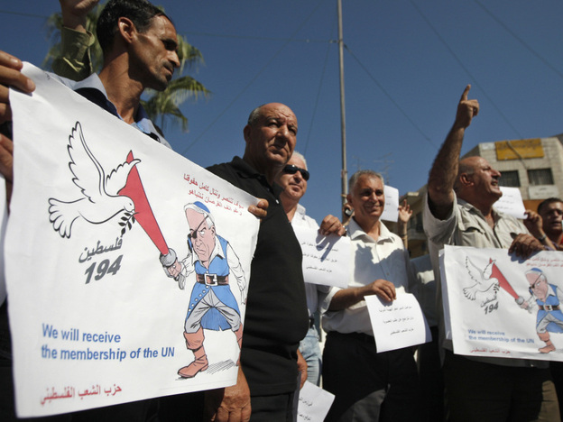 Palestinians hold signs depicting Israel's Prime Minister Benjamin Netanyahu as a pirate during a demonstration supporting the Palestinians' bid for statehood, in the West Bank city of Ramallah on Monday.