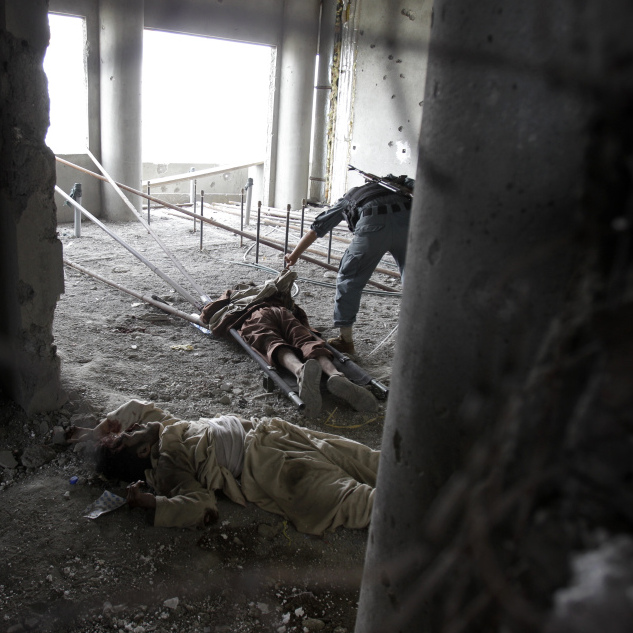 Inside the building from which the attack was staged, an Afghan soldier checked one attacker's body earlier today. Another dead insurgent lies nearby. Bullet holes riddle the walls.