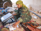 A fighter loyal to the Transitional National Council sits with money that has been donated to pay fighters at a checkpoint outside Bani Walid, Libya, on Monday. It was widely feared that ousted leader Moammar Gadhafi and his supporters spirited away much of the country's wealth. But those fears have yet to materialize, as Libya's central bank holdings appear to remain largely intact. A fighter loyal to the Transitional National Council sits with money that has been donated to pay fighters at a checkpoint outside Bani Walid, Libya, on Monday. It was widely feared that ousted leader Moammar Gadhafi and his supporters spirited away much of the country's wealth. But those fears have yet to materialize, as Libya's central bank holdings appear to remain largely intact.