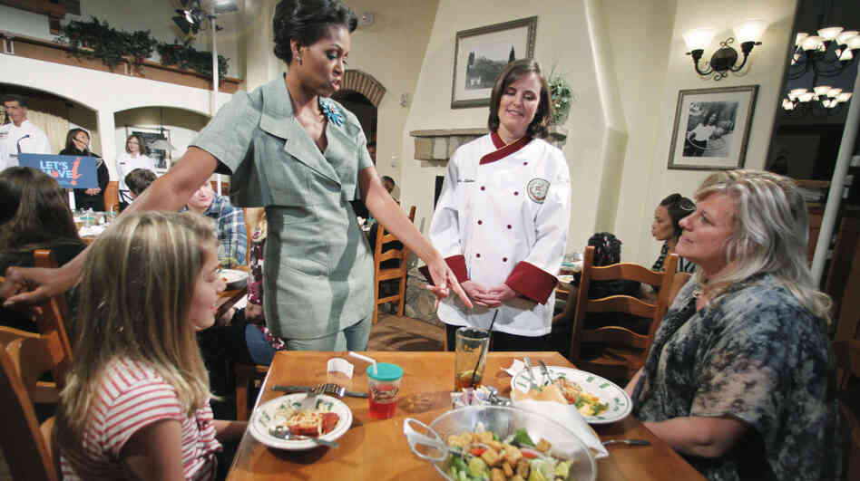 First Lady Michelle Obama, accompanied by Darden chef Julie Elkinton, talks to Charisse McElroy, right, and her daughter Jacqueline McElroy, 9, during an event at Olive Garden in Hyattsville, Md. on Thursday.