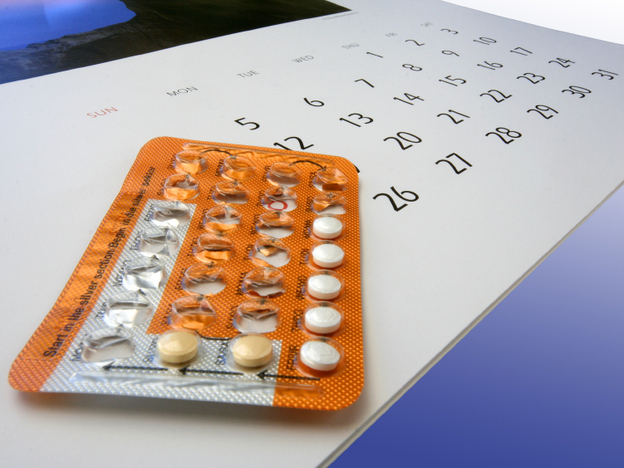 Birth control pills on a calendar.