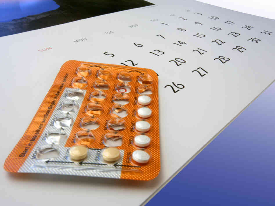 Birth control pills on a calendar.