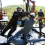Workers move a section of well casting at a natural gas well site in Pennsylvania. Energy expert Daniel Yergin says that in addition to trucks and traffic, natural gas production can bring jobs and economic growth to gas-rich areas.
