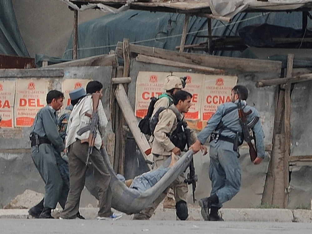Afghan security personnel carry a wounded colleague across a street in Kabul on Sept. 14, after Taliban fighters attacked the most heavily protected part of the Afghan capital. Adm. Mike Mullen, chairman of the Joint Chiefs of Staff, said Thursday before a Senate panel that the Haqqani network of militants, supported by Pakistan, was responsible for this attack, among others.