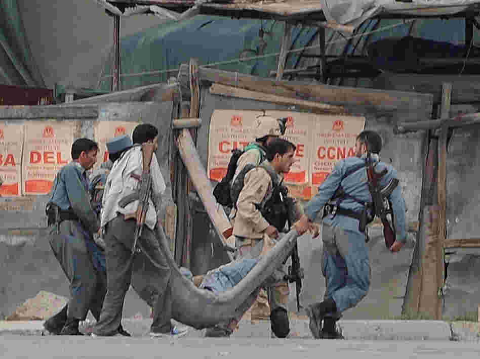 Afghan security personnel carry a wounded colleague across a street in Kabul on Sept. 14, after Taliban fighters attacked the most heavily protected part of the Afghan capital. Adm. Mike Mullen, chairman of the Joint Chiefs of Staff, said Thursday before a Senate panel that the Haqqani network of militants, supported by Pakistan, was responsible for this attack, among others.