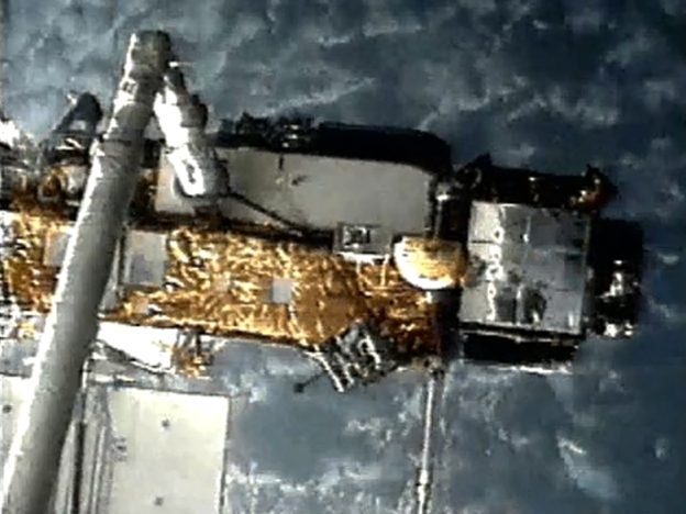 A screen grab from NASA shows UARS attached to the robotic arm of the space shuttle Discovery in 1991 as it was deployed.
