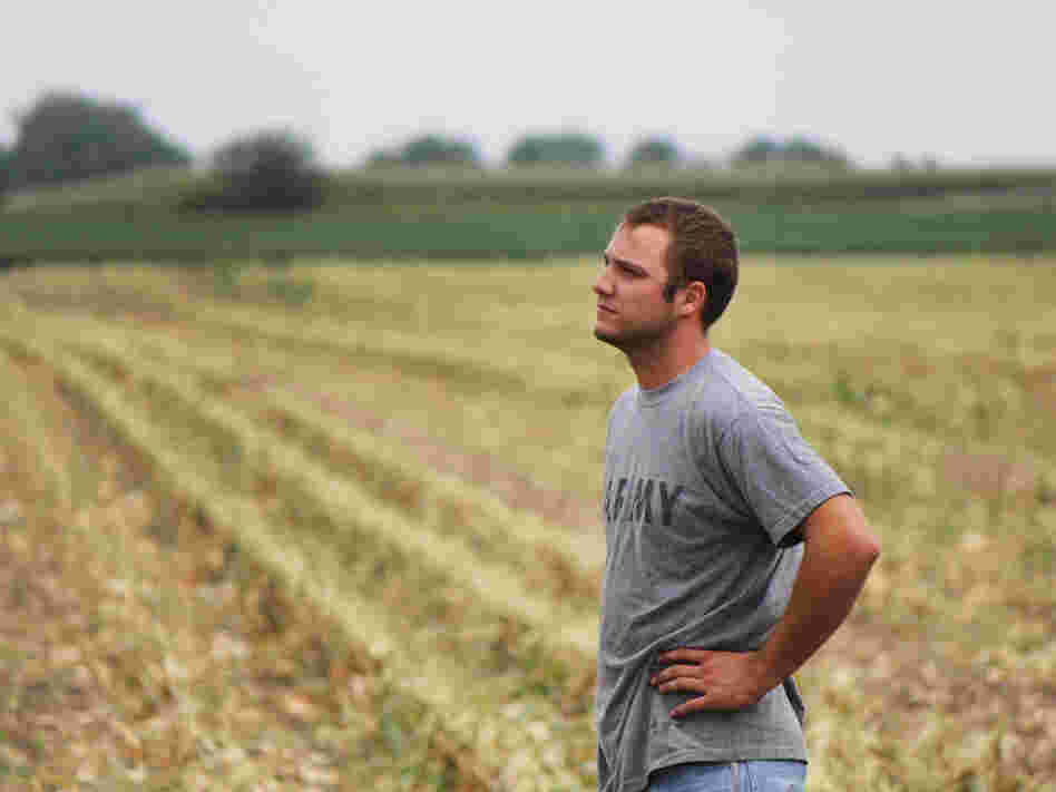 Austin Bruns stands on land owned by a contractor for Monsanto, an agriculture corporation. Bruns helps with seed corn production there, and also rents 150 acres elsewhere.