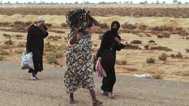 Libyans flee on foot along the main road heading west, away from Sirte, on Tuesday. Sirte, cut off from the rest of the country, is the last major town controlled by forces loyal to toppled dictator Moammar Gadhafi.