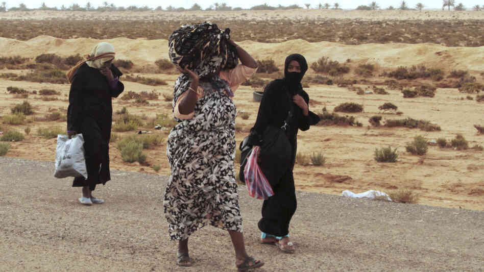 Libyans flee on foot along the main road heading west, away from Sirte, on Tuesday. Sirte, cut off from the rest of the country, is the last major town controlled by forces loyal to toppled dictator Moammar Gadhafi.