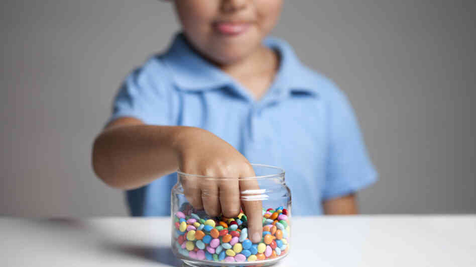 Boy taking candy from a jar