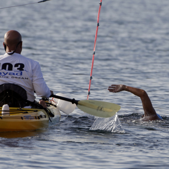 A member of Diana Nyad's support team accompanies her as she begins her swim from Cuba to Florida at the Hemingway Marina in Havana, Cuba on Friday.