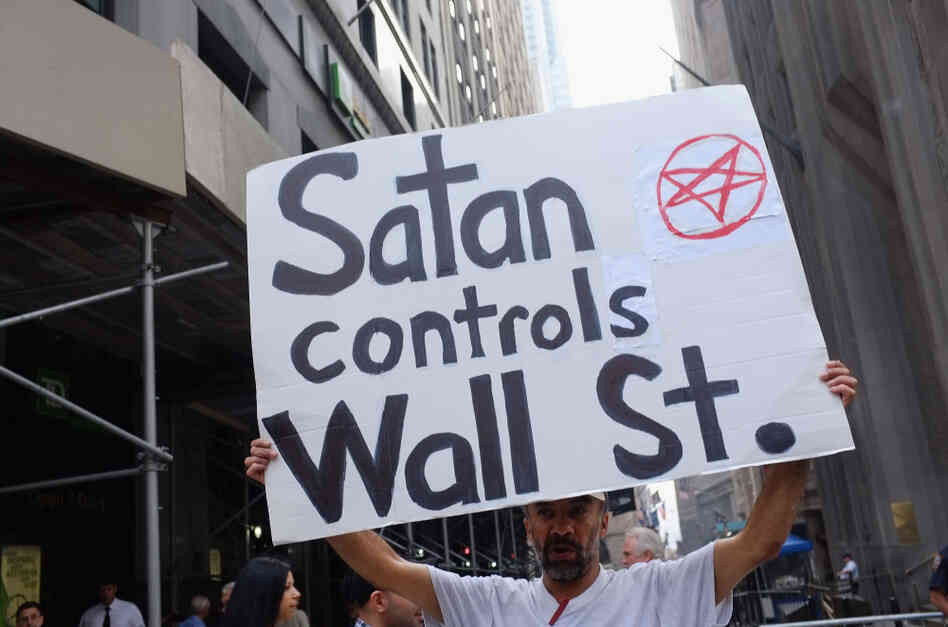A demonstrator holds up a sign in front of the New York Stock Exchange in New York City. Hundreds of activists affiliated with the "Occupy Wall Street" demonstrations have begun living in a park in the Financial District near Wall Street. A demonstrator holds up a sign in front of the New York Stock Exchange in New York City. Hundreds of activists affiliated with the "Occupy Wall Street" demonstrations have begun living in a park in the Financial District near Wall Street.