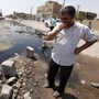 A man stands in a sewage-filled street in Fallujah in 2010. The Fallujah wastewater treatment system was left unfinished more than four years past the initial deadline. The sewage facility is among hundreds of projects funded by U.S. taxpayers that remain abandoned or incomplete, wasting more than $5 billion, according to auditors.