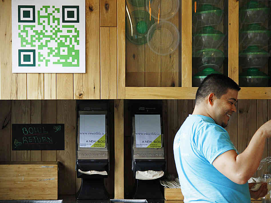 Manuel Martinez, the manager of a popular salad restaurant in Washington, D.C., called Sweetgreen, assists a customer. Martinez says customers use the QR code on the wall to learn about promotions and to get discounts. Manuel Martinez, the manager of a popular salad restaurant in Washington, D.C., called Sweetgreen, assists a customer. Martinez says customers use the QR code on the wall to learn about promotions and to get discounts.
