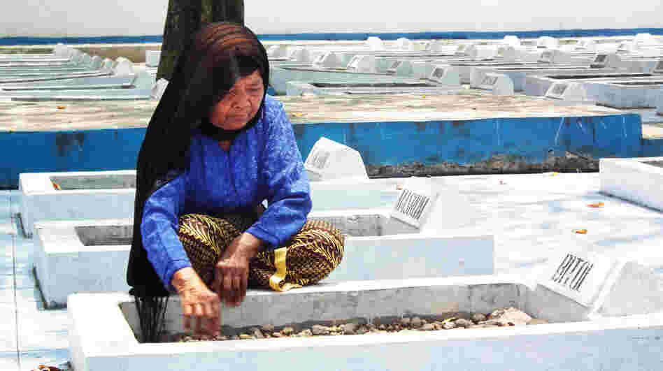 Cawi Binti Baisan, 84, squats beside the grave of her first husband, Bitol, a farmer who was executed by Dutch soldiers in 1947. She is one of seven remaining widows of the more than 400 estimated massacre victims. A Dutch court recently ruled that the Dutch government must compensate the widows for their losses.