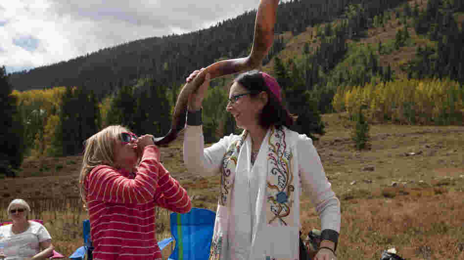 A 10-year-old girl blows a shofar with the help of Cantor Robbi Sherwin during Rosh Hashana services in the mountains of Crested Butte, Colo., last year. Rosh Hashana marks the beginning of the Jewish new year.