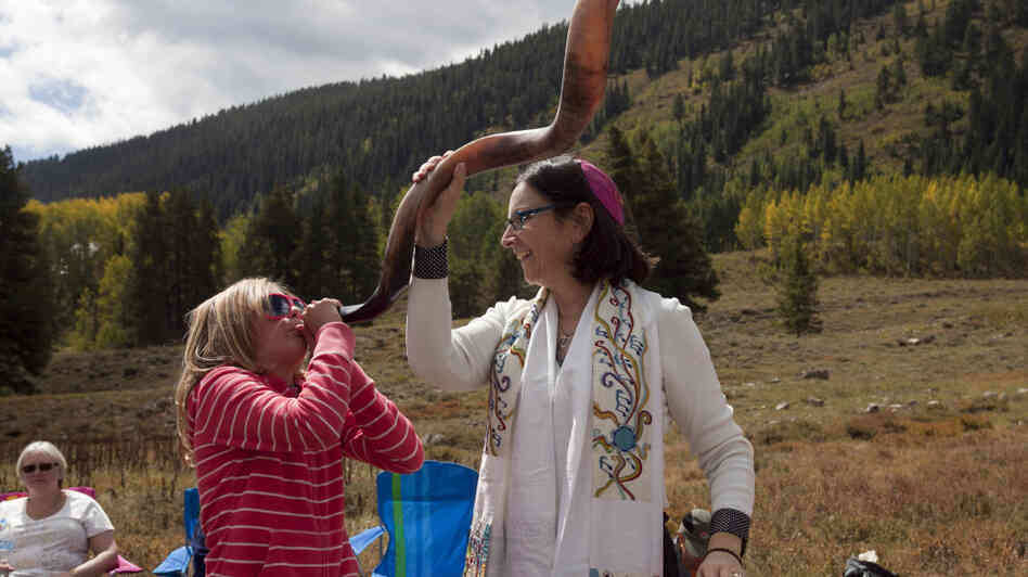A 10-year-old girl blows a shofar with the help of Cantor Robbi Sherwin during Rosh Hashana services in the mountains of Crested Butte, Colo., last year. Rosh Hashana marks the beginning of the Jewish new year.
