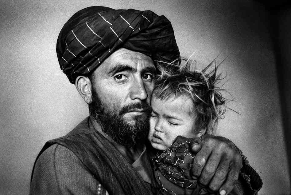 A father with his ill daughter waits for treatment at a Swedish Committee clinic, Takhar Province, 2000.