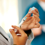 A doctor prepares a shot. A doctor prepares a shot.