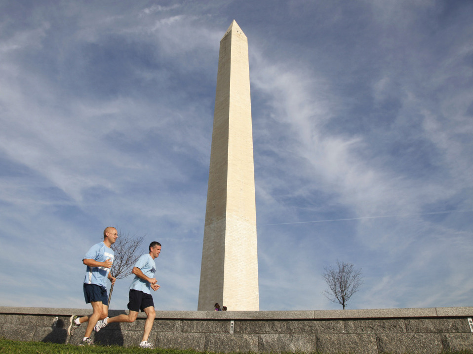 Joggers run past the Washington Monument in Washington, Wednesday, Aug. 24, 2011, which remains closed after Tuesday's earthquake.