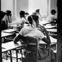 An unidentified African American student sits inside a classroom at Clinton High School, which was newly integrated when this photo was taken on Aug. 31, 1956. She sits in a rear seat near the door and is separated by empty desks as the white children sit at the far side of the room.