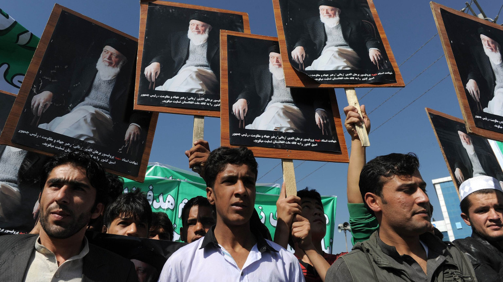 Afghans hold portraits of former President Burhanuddin Rabbani,  as they shout anti-government slogans  during a demonstration in Kabul on Tuesday. Last week's killing of Rabbani, an ethnic Tajik, was the latest targeting his party and it has stoked fears of increased factionalism.