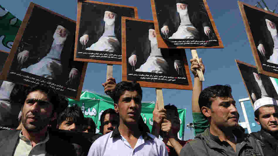 Afghans hold portraits of former President Burhanuddin Rabbani,  as they shout anti-government slogans  during a demonstration in Kabul on Tuesday. Last week's killing of Rabbani, an ethnic Tajik, was the latest targeting his party and it has stoked fears of increased factionalism.