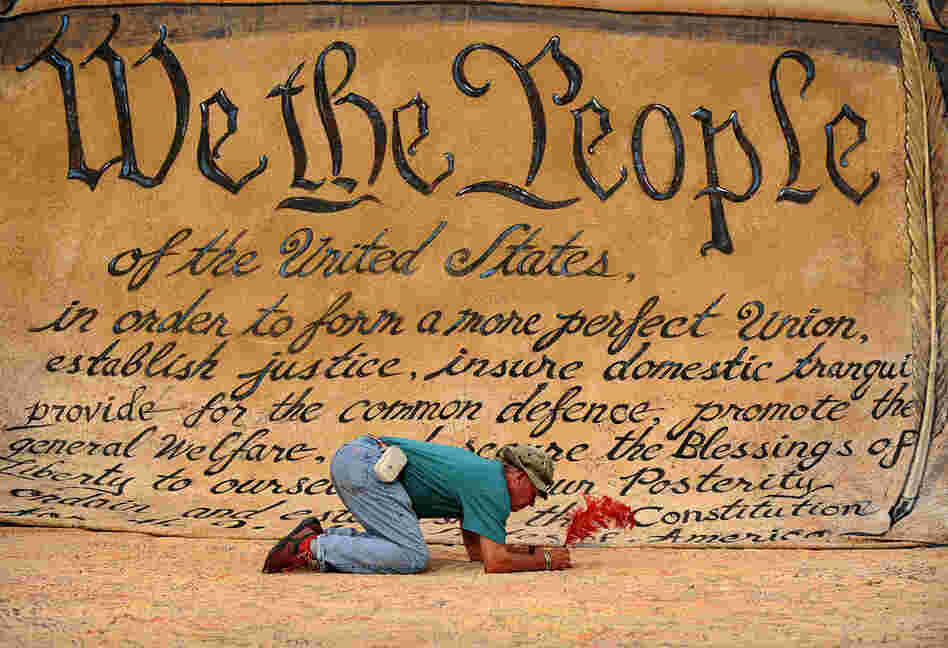 A man signs a huge banner depicting the Preamble to the Constitution during an Occupy DC anti-corporations protest at Freedom Plaza in Washington, D.C. 
