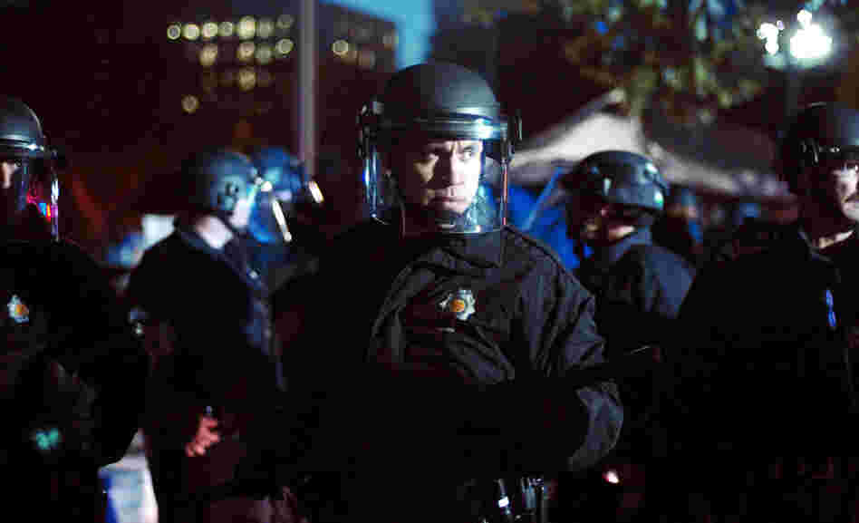 Dozens of police in riot gear pushed Occupy Denver protesters into retreat outside the state Capitol on Friday. 