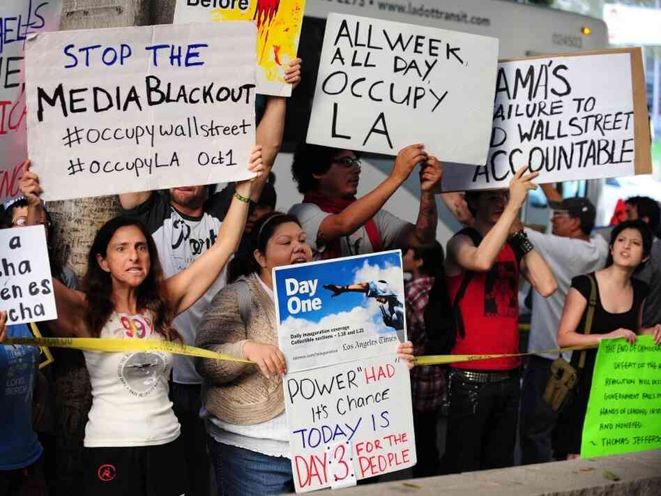 Protesters shout slogans while holding banners Monday at  Occupy Wall Street protests in Los Angeles. 